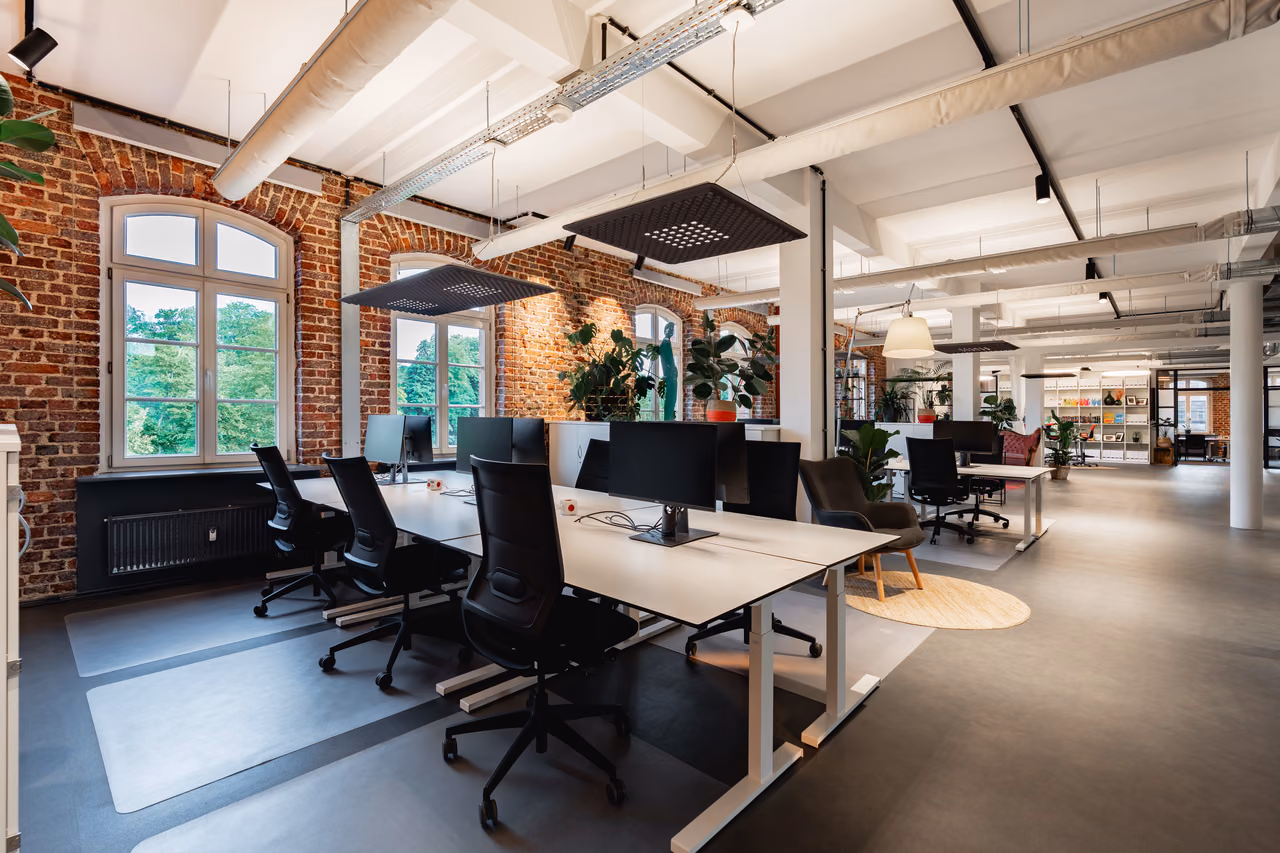 Co-Working-Fläche von StartMiUp Minden mit Backsteinwand und Bildschirmarbeitsplätzen