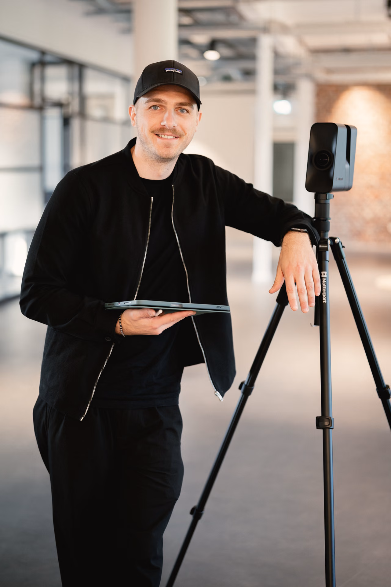 René Röbke mit iPad, an das Stativ der 3D-Kamera gelehnt